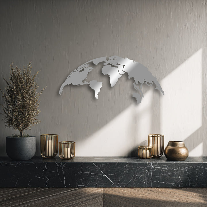 The loudest element is a reflective silver world map metal art for wall, a modern global silhouette shining on a textured wall.