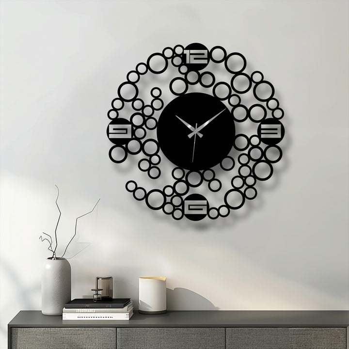Seen as the focal point, this modern bubble ring metal wall clock features a minimalist geometric design creating a striking and unique metal wall art piece.