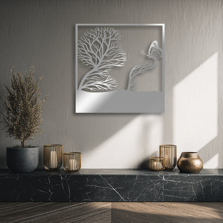 The brightest area showcases natural light illuminating the lower section of a whimsical tree and butterfly artistic nature decorative metal art piece.
