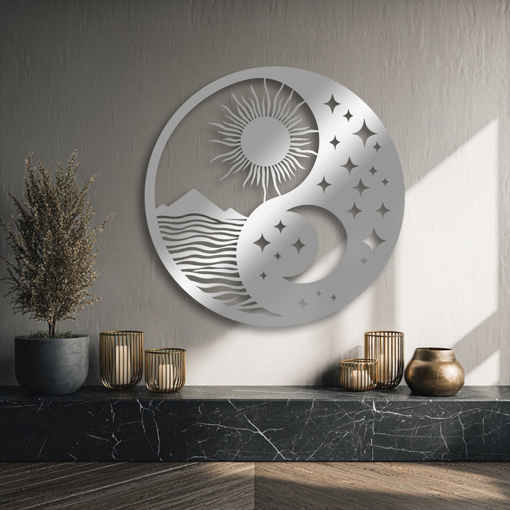 The matte silver finish of this decorative metal art showcases a celestial balance yin yang design with sun, moon, and landscape.