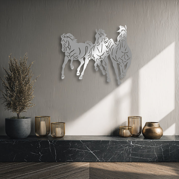 The striking focal point features dynamic galloping trio horses metal art for wall, casting shadows on a textured wall under direct sunlight.