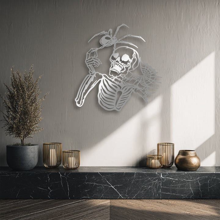 The stillness of this dark aesthetic horror decor scene highlights unique metal wall art depicting a gothic skeleton holding a spider.