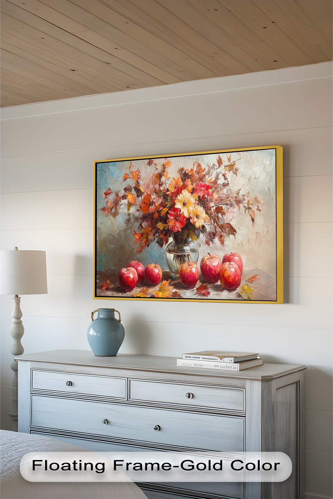 This warm and vibrant still life painting features a glass vase filled with autumn flowers and leaves, surrounded by ripe red apples on a rustic surface.