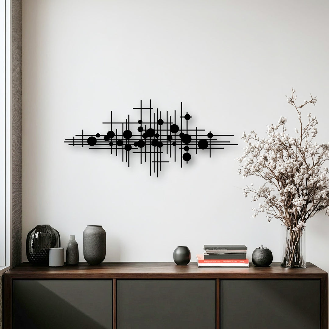 Horizontally oriented unique metal wall art featuring an abstract geometric shape of intersecting lines and various sized circles for modern decor.