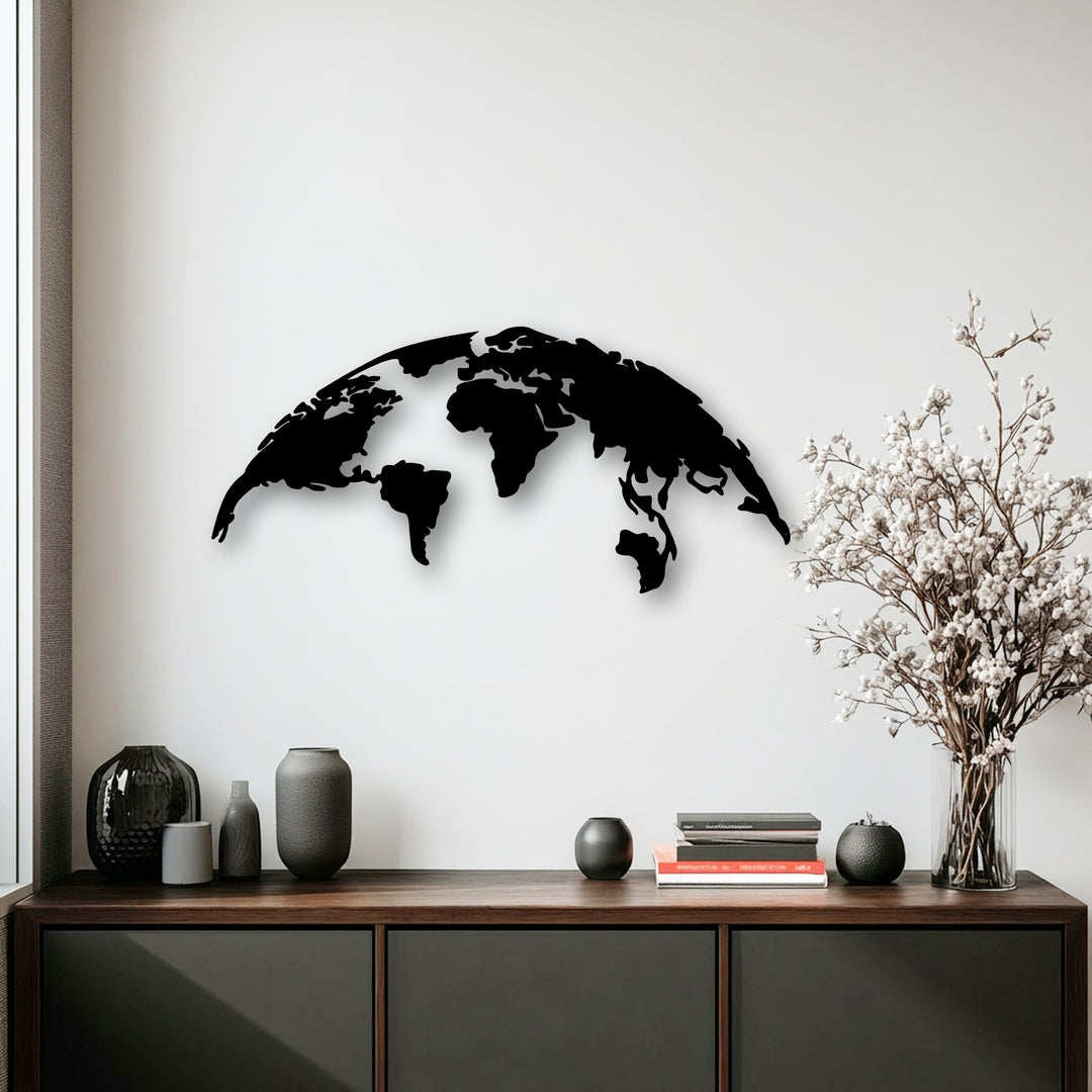 A striking black silhouette global map, a modern metal art for wall piece, prominently features above a dark wooden cabinet with vases.