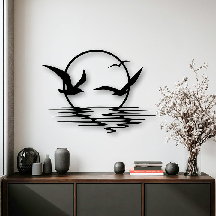 Dramatic light and shadow sculpt this unique metal wall art, depicting soaring seagulls silhouetted against a radiant sunset and reflective ocean waves.