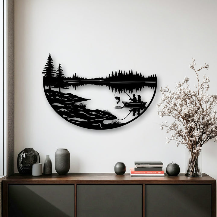 A striking semi-circular metal art for wall displays a tranquil fishing lake scene composed of sharp angular tree silhouettes and smooth horizontal lines.