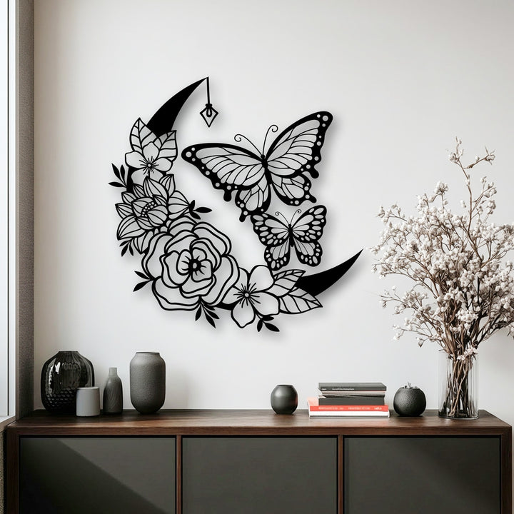 Delicate white blossoms fill a clear vase, subtly complementing the enchanting moon and butterfly decorative metal art.
