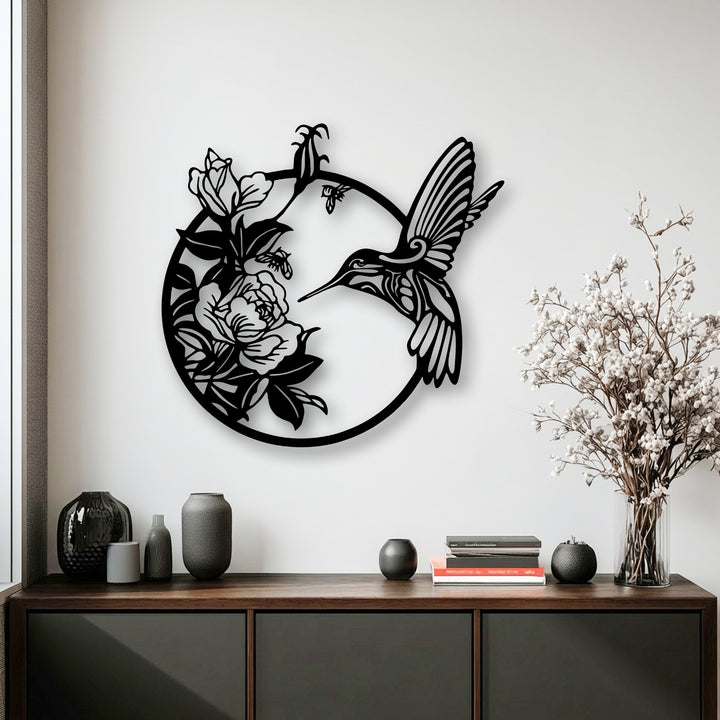 The negative space intricately defines the graceful hummingbird and blooming flowers, forming a stunning piece of decorative metal art.