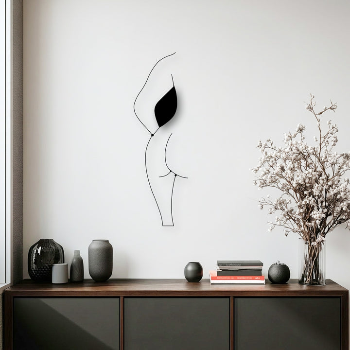 A compelling visual rhythm emanates from the flowing lines of the minimalist female silhouette, an elegant decorative metal art piece.