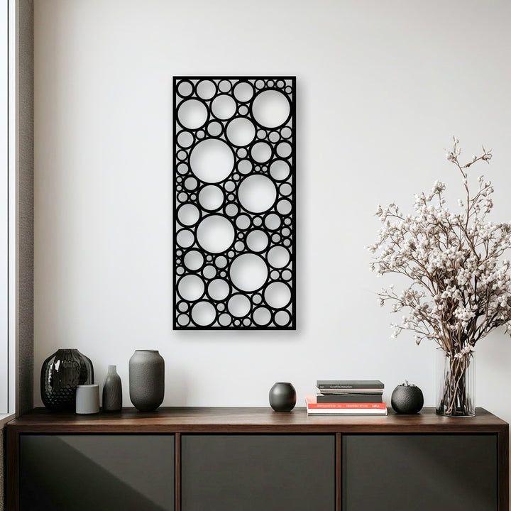 Delicate white blooms gently contrast the modern abstract geometric circle pattern of the decorative metal art.