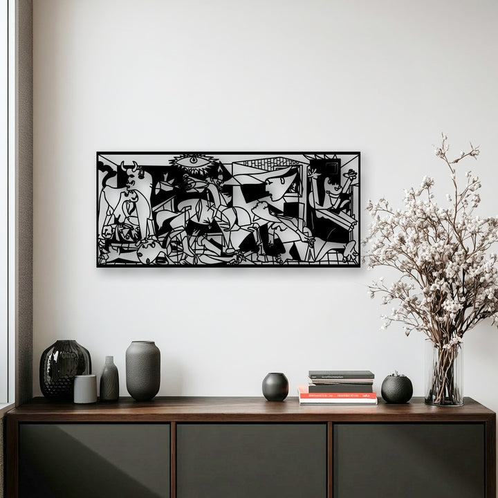 A bright, pristine white wall provides a clean backdrop for the striking Guernica-inspired unique metal wall art, with a subtle window frame on the left.