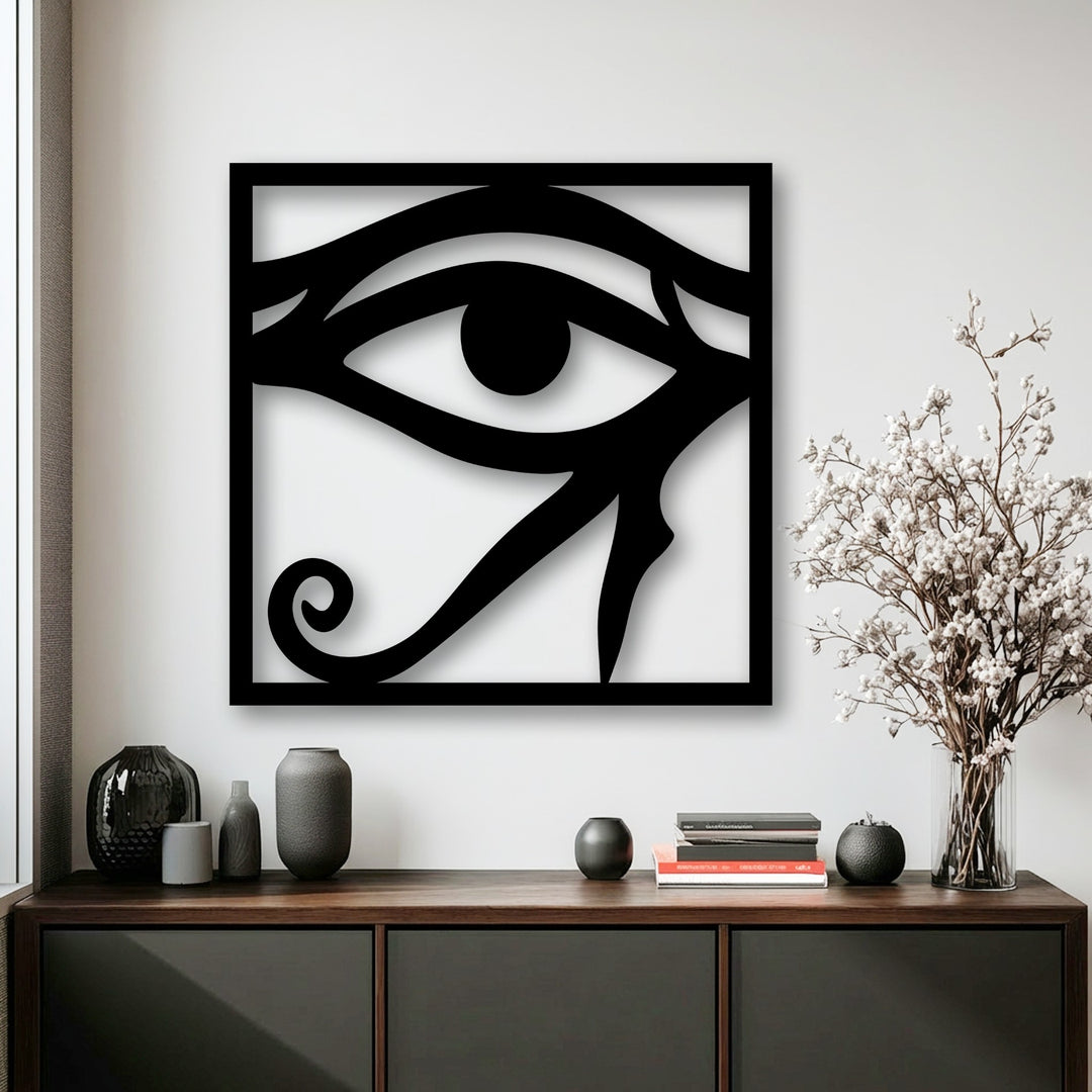 A striking black Eye of Horus decorative metal art piece, featuring ancient Egyptian symbolism prominently displayed against a white wall.