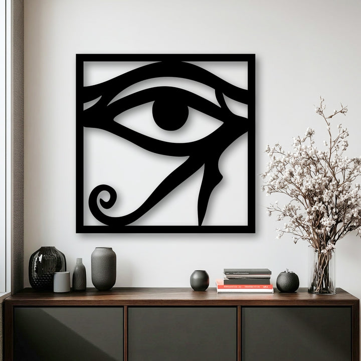 A striking black Eye of Horus decorative metal art piece, featuring ancient Egyptian symbolism prominently displayed against a white wall.