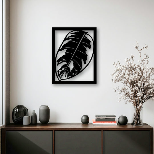 Vertically oriented unique metal wall art featuring a striking rectangular frame enclosing a stylized monstera leaf design.