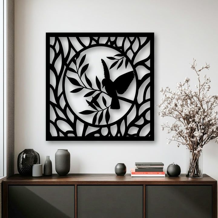 The central subject shows a graceful bird silhouette perched on a branch within a circular, leafy design, forming elegant metal artwork.
