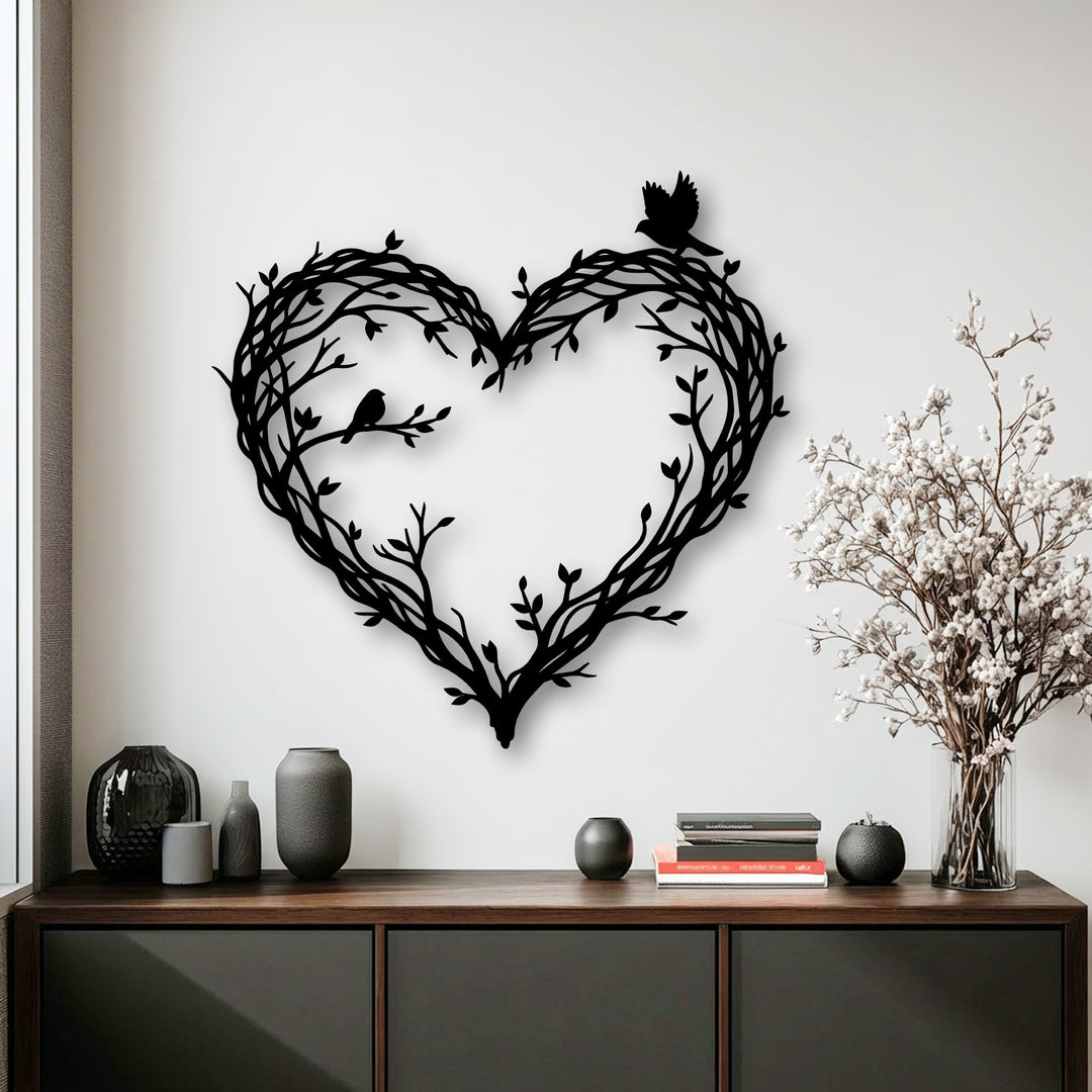 The most prominent feature is the striking black metal art for wall, an intricate heart-shaped design of branches with two perched birds.