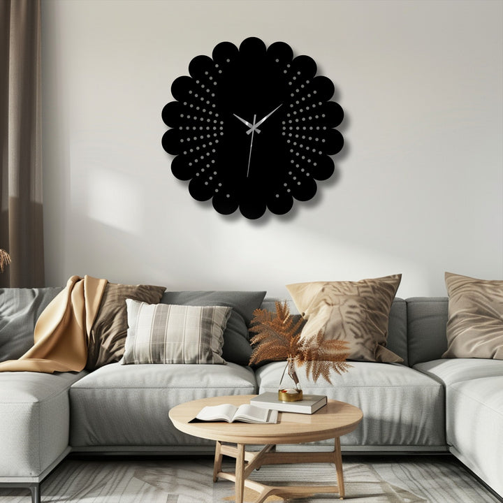 Foreground view focusing on an open book and vase atop a light wood coffee table, positioned before a metal artwork scalloped dot pattern wall clock.