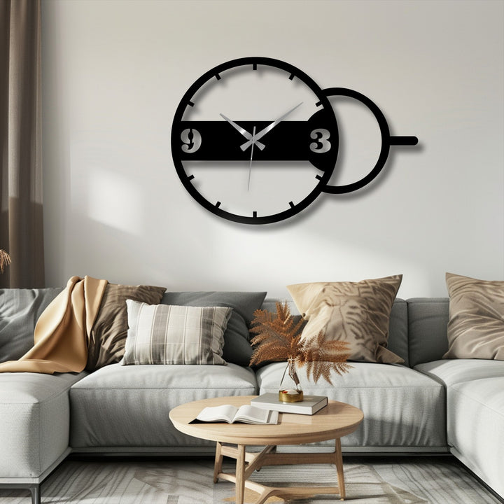 Dark shadows highlight the decoration wall art as the round modern metal wall clock's curves cast contrasting shades on the light wall.