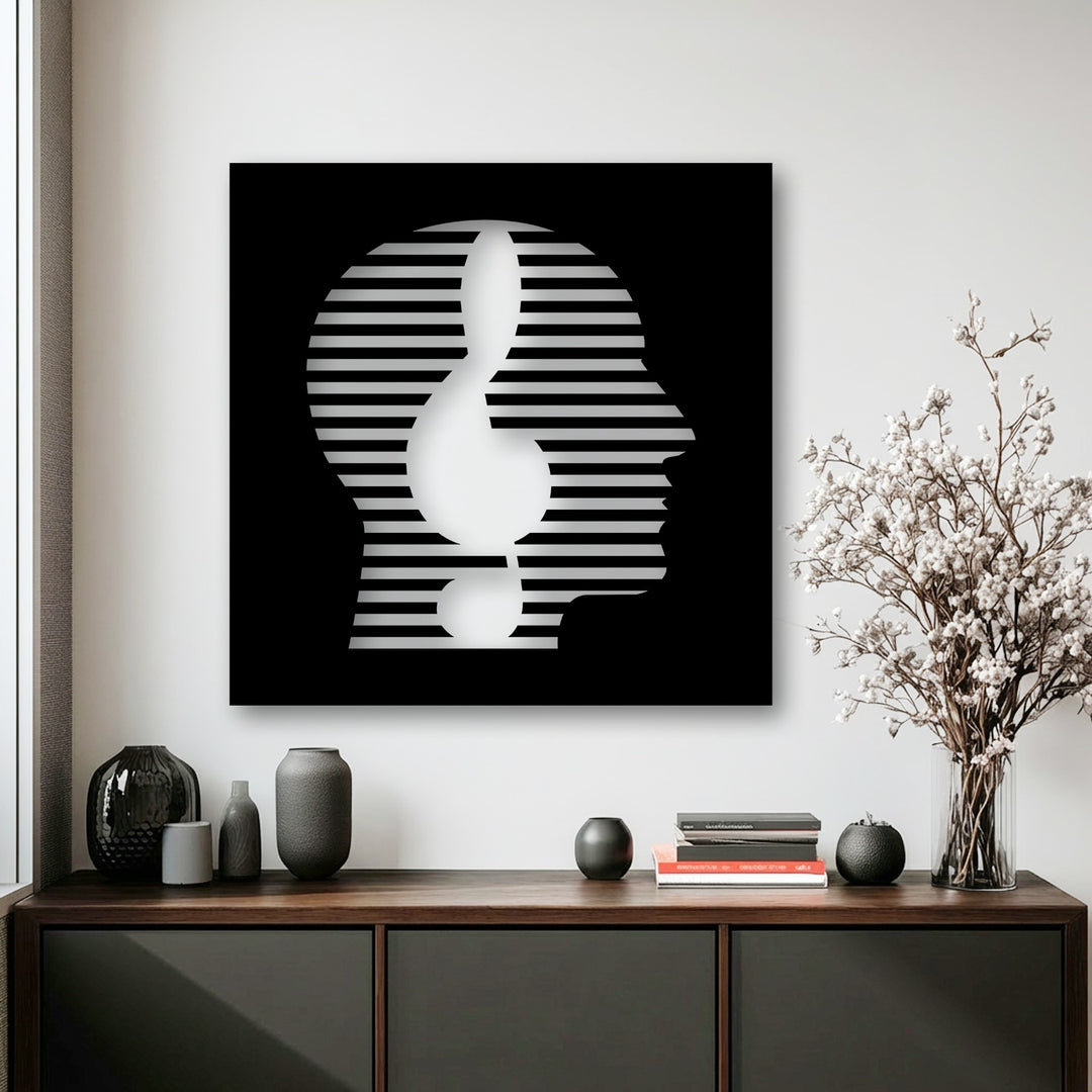 The realistic detail of this black and white abstract face metal wall decor highlights the striking line portrait within a contemporary setting.