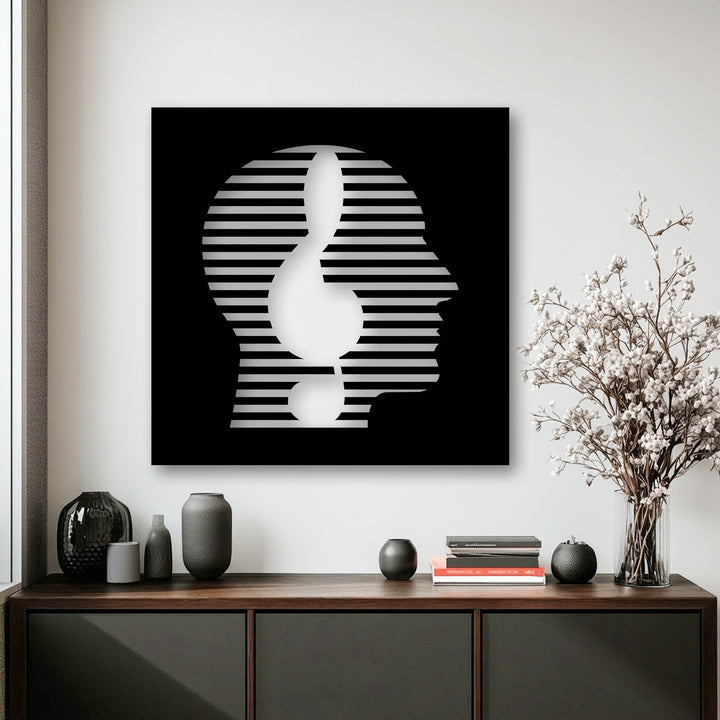 The realistic detail of this black and white abstract face metal wall decor highlights the striking line portrait within a contemporary setting.