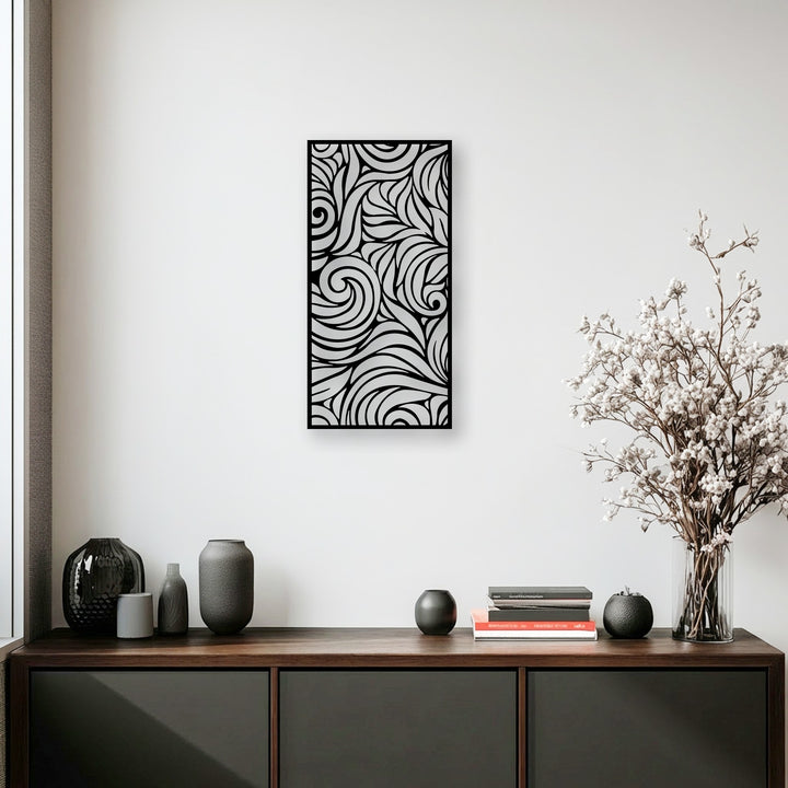 The darkest area highlights an ornamental flow metal wall decor panel with abstract swirls above a dark wooden cabinet and deep gray vases.