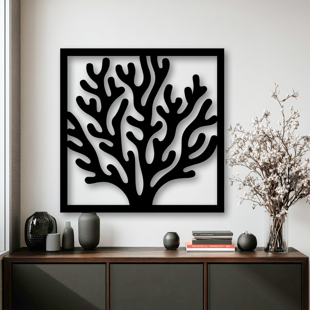 The tranquil mood of a sophisticated coastal space is enhanced by a framed black coral decorative metal art piece, complementing dark vases and white flowers.