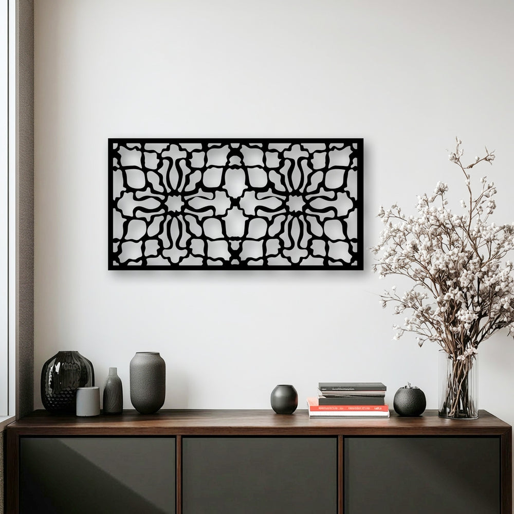 The plain white wall provides a stark contrast to the black ornamental geometric pattern metal artwork, creating a striking focal point.