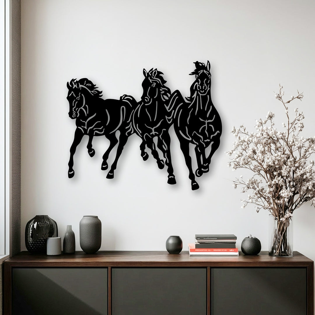 White negative space sharply defines the contours of the decorative metal art featuring a trio of dynamic running horses.