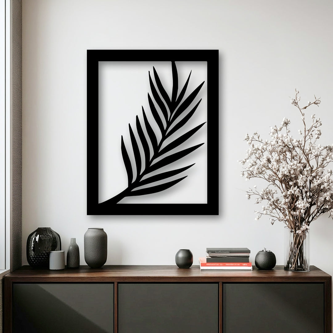 The high material quality of this minimal palm leaf metal artwork is evident in its precise silhouette and smooth black finish.