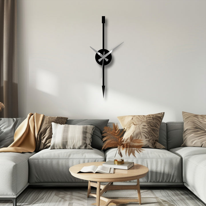 Illuminated by a soft glow, the minimalist vertical arrow modern metal wall clock is a stunning example of metal art for wall, contrasting against the light wall behind the sofa.