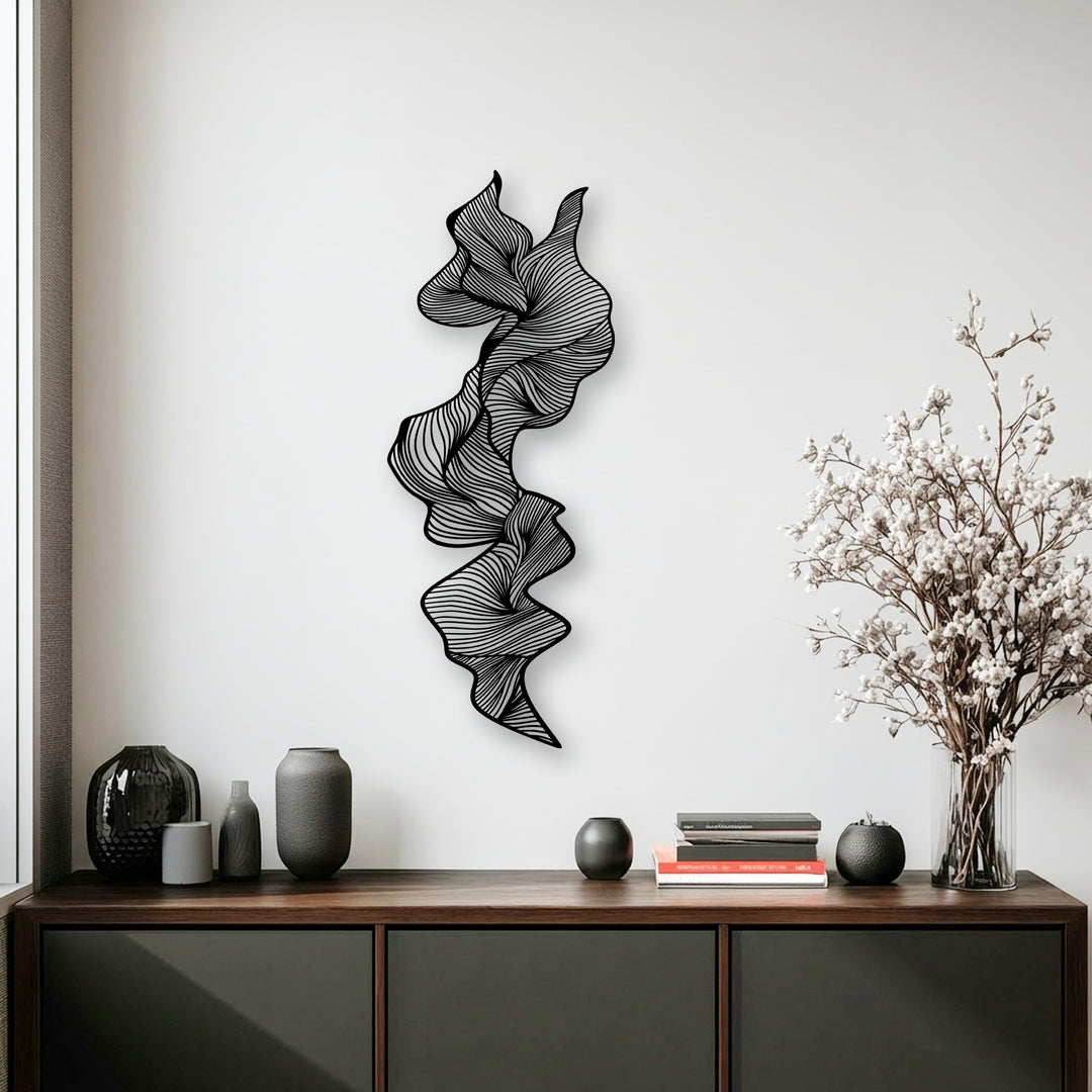 A multi-layered vertical abstract metal artwork with intricate flowing lines creates dynamic depth against a white wall, enhancing the modern line sculpture.