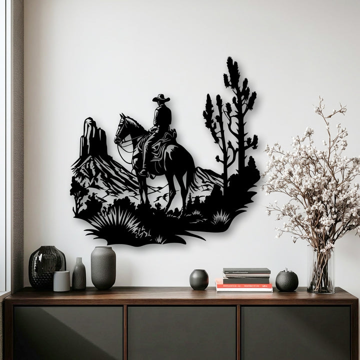 Against the brightest area, a vibrant white wall, hangs detailed metal art for wall depicting a Western Cowboy Landscape with a Desert Horse Rider.