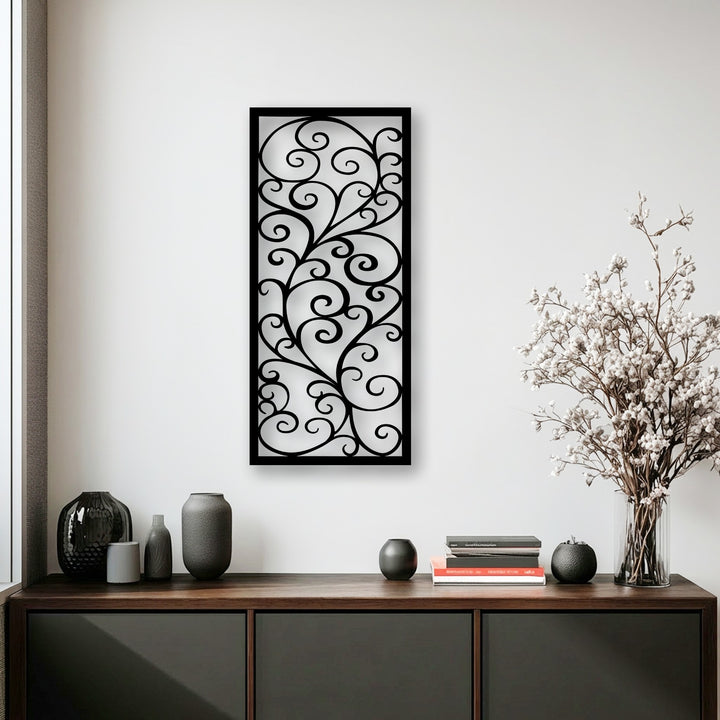 The elegant scroll pattern metal wall decor showcases a dramatic transition from its dark, intricate design to the bright white wall, creating visual depth.