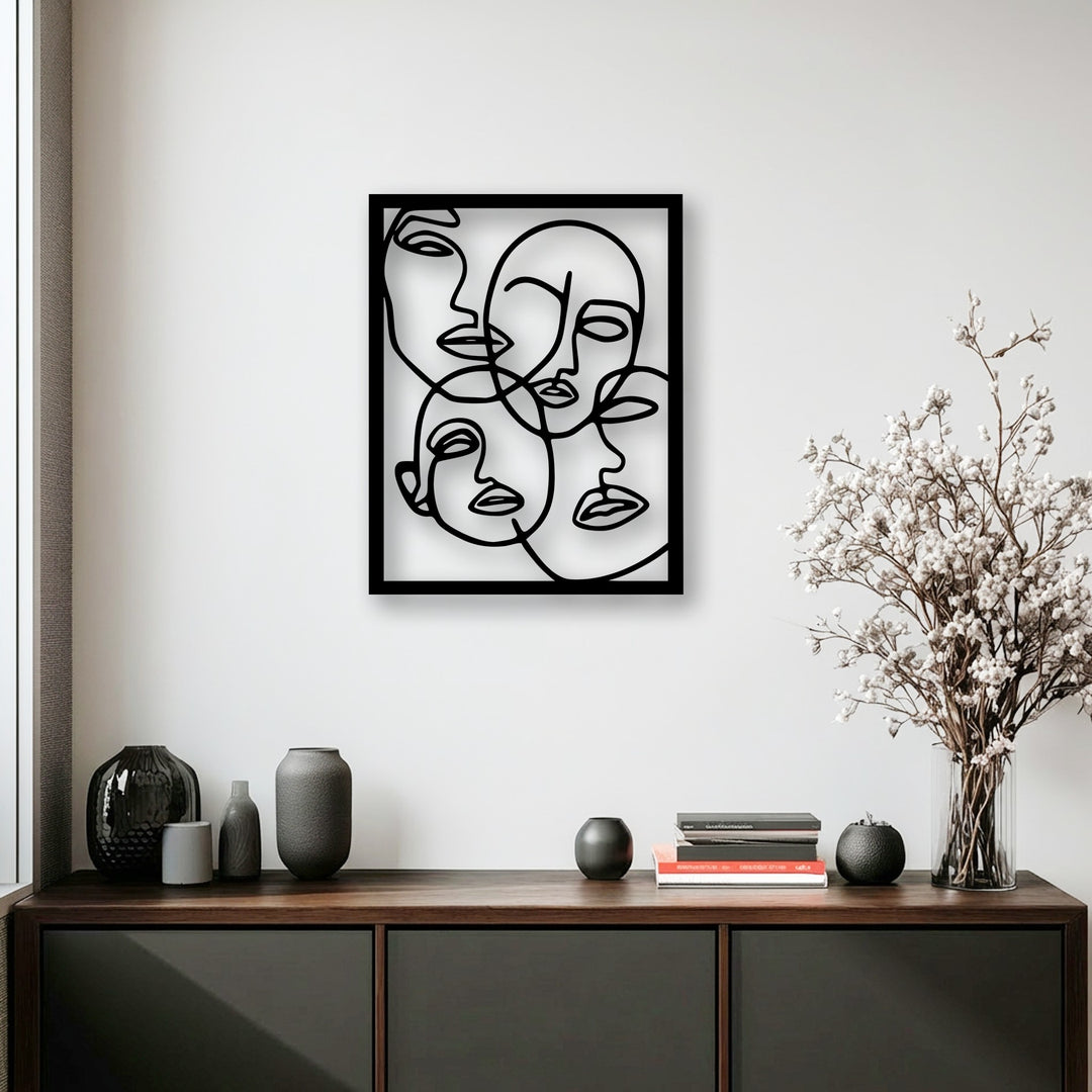Striking color contrast is evident in this minimalist abstract faces metal wall decor against a crisp white wall, complemented by dark vases.