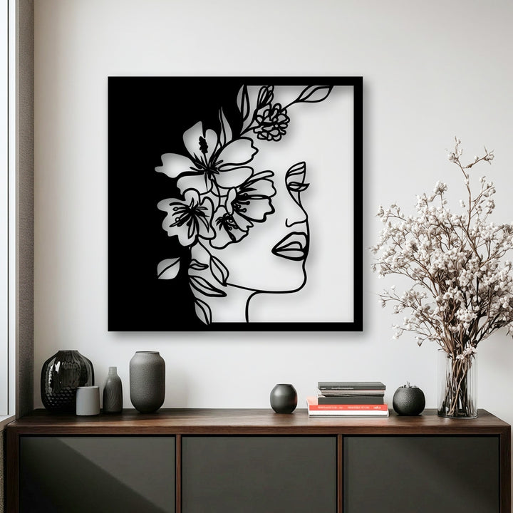 The organic forms of the elegant floral woman line art create a striking decorative metal art piece against a contrasting background.