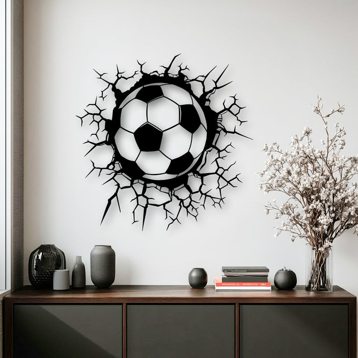 The intricate, jagged cracks of the breaking wall effect around the soccer ball form dynamic metal art for wall.