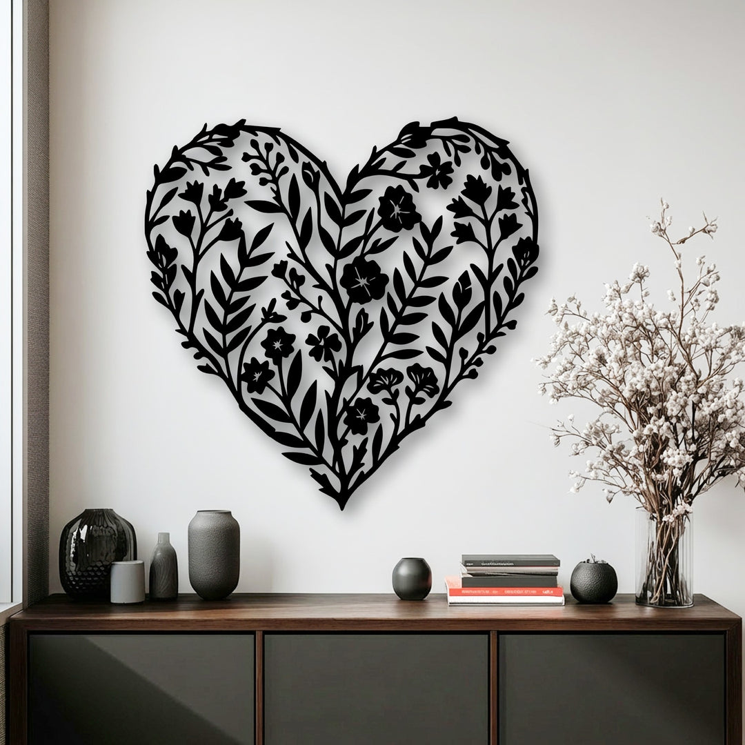 A pristine white wall serves as the minimalist background for an intricate black botanical heart metal wall decor piece.