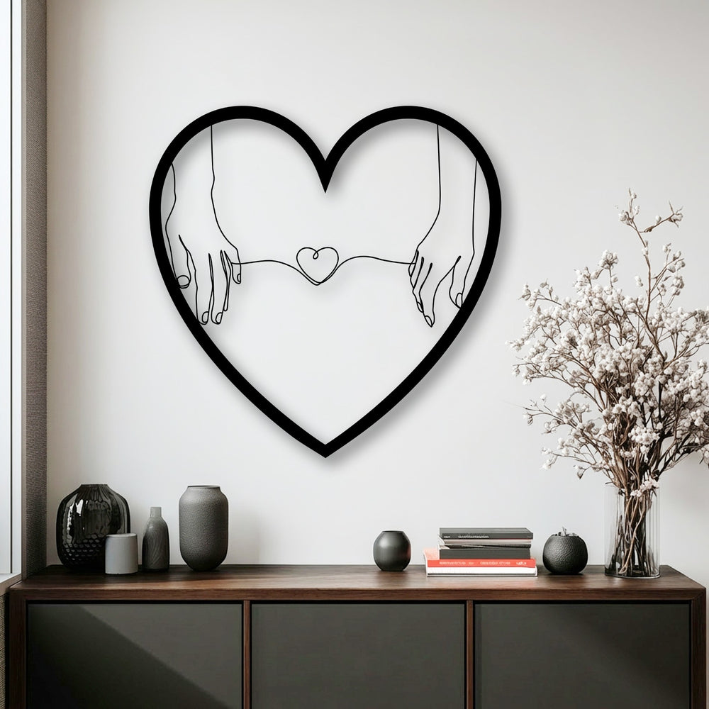 The smooth, matte finish of the unique metal wall art, shaped like connected hearts, creates a striking contrast against the textured vases below.