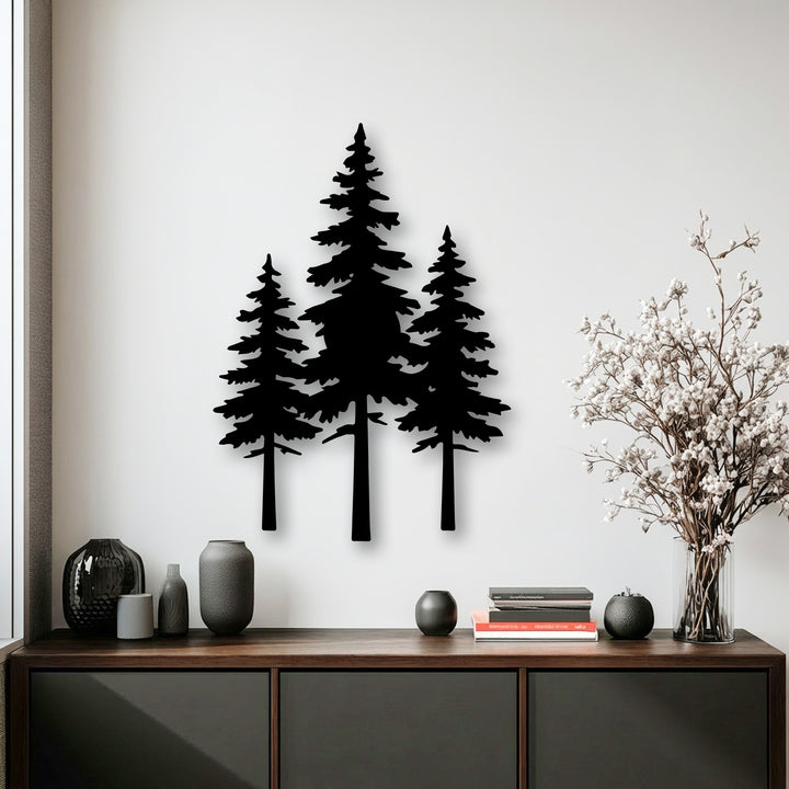 Smooth white wall contrasted with the matte black texture of decorative metal art pine tree silhouettes, alongside textured vases and delicate dried flowers.