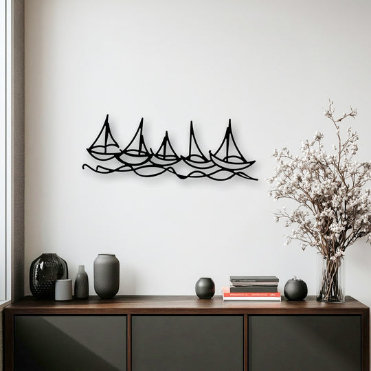 The foreground detail captures a rich wooden console table displaying dark, textured vases, books, and a delicate bouquet, beneath elegant minimal boat line metal artwork.
