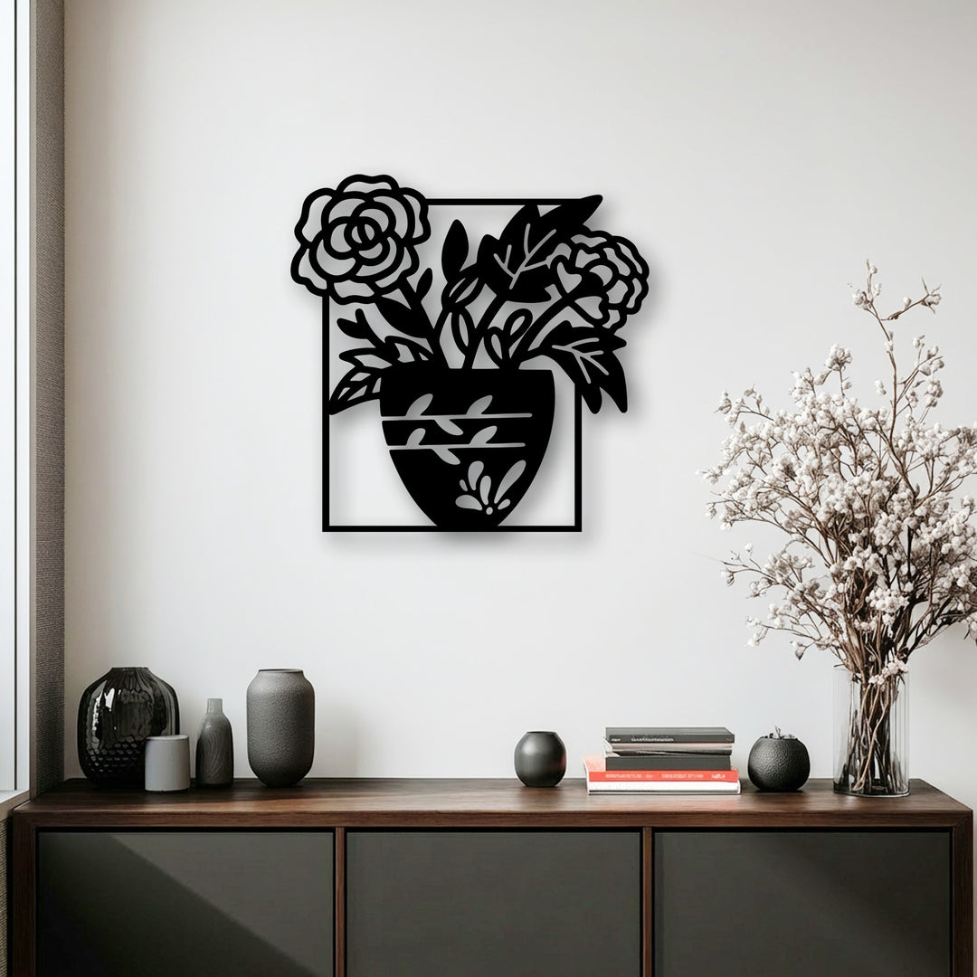 The serene white wall highlights the unique metal wall art of a blooming floral vase, creating a tranquil display above the neatly arranged console.