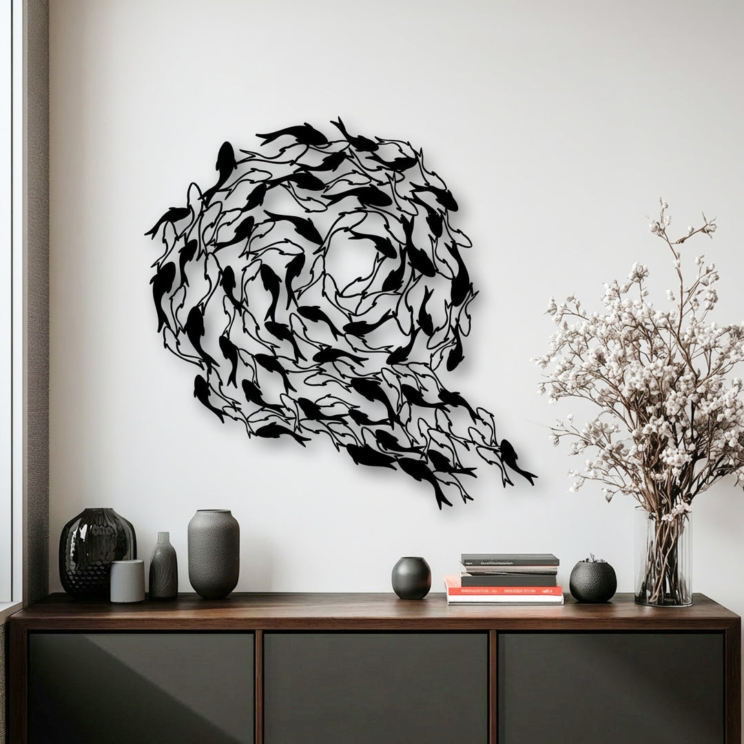A captivating decorative metal art piece showcasing a large black sculpture of numerous koi fish arranged in a beautiful circular, flowing pattern on a white wall.
