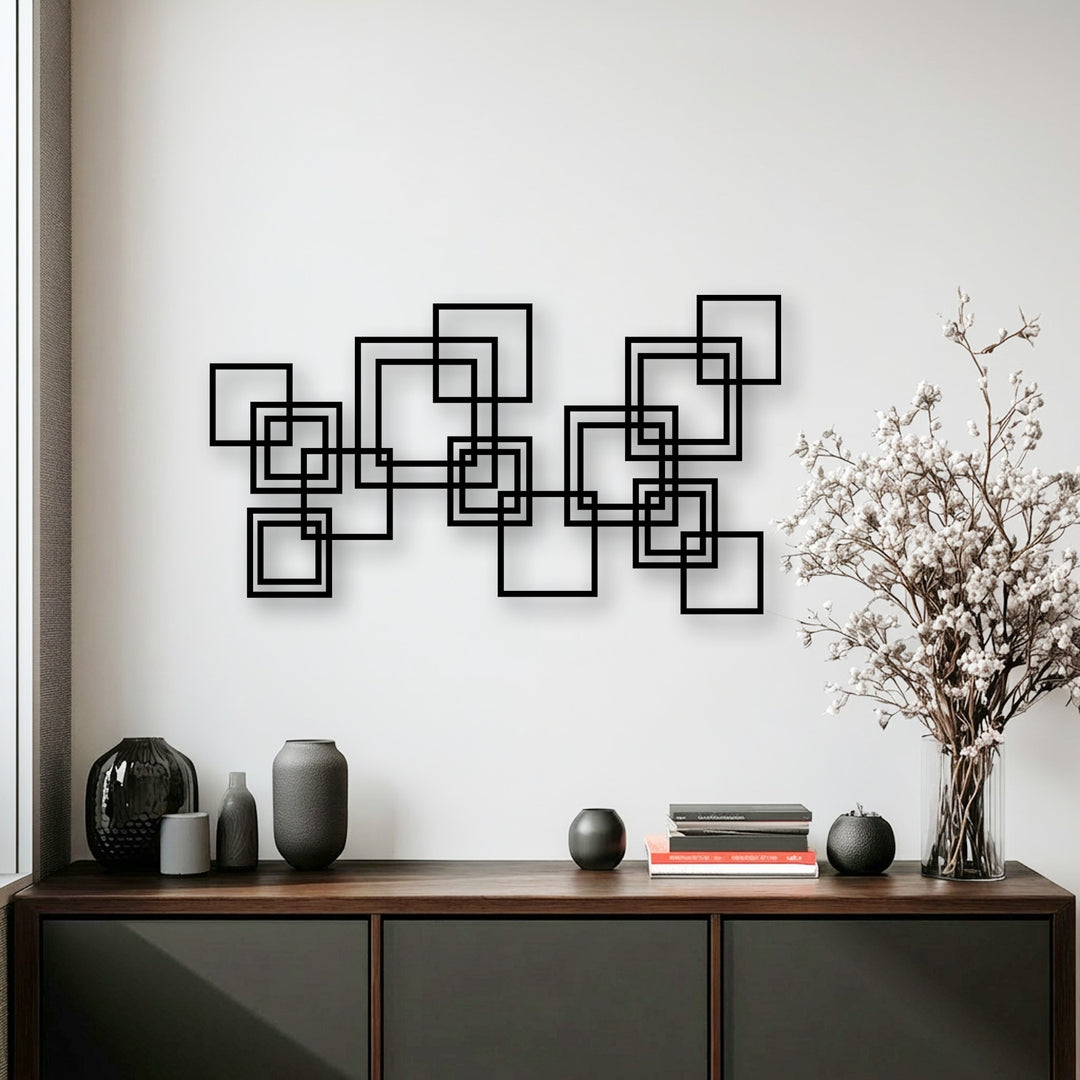 Bold interlocking squares metal wall art forms a striking geometric decoration wall art piece above a sleek wooden cabinet.