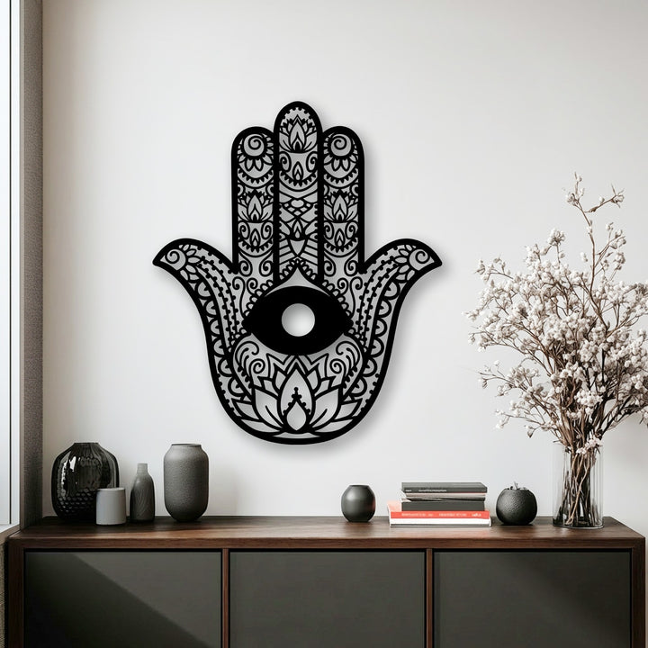 The cool color temperature accentuates the intricate Hamsa hand evil eye metal decoration wall art placed above a sleek dark cabinet.