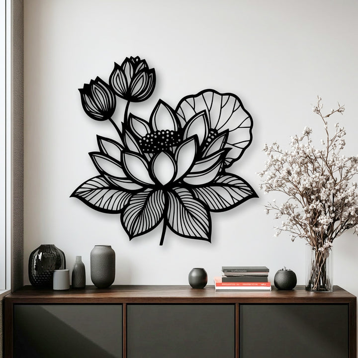 The intricate edges and clean borders of the black lotus floral metal wall decor piece are sharply defined against the white wall.