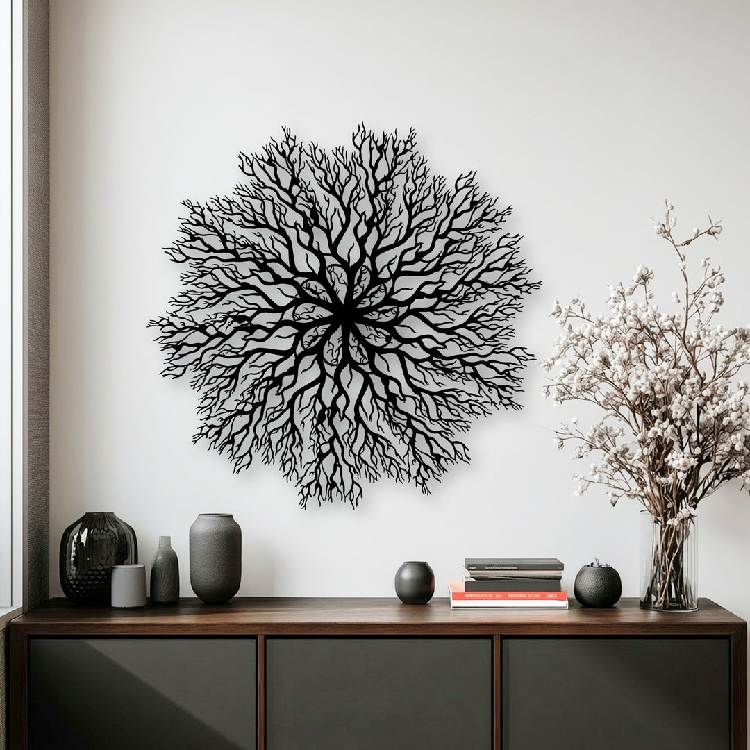 Predominantly white, this interior shot highlights an intricate black tree roots mandala metal artwork centered above a sleek wooden cabinet.