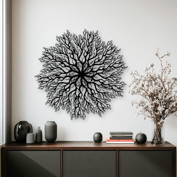 Predominantly white, this interior shot highlights an intricate black tree roots mandala metal artwork centered above a sleek wooden cabinet.