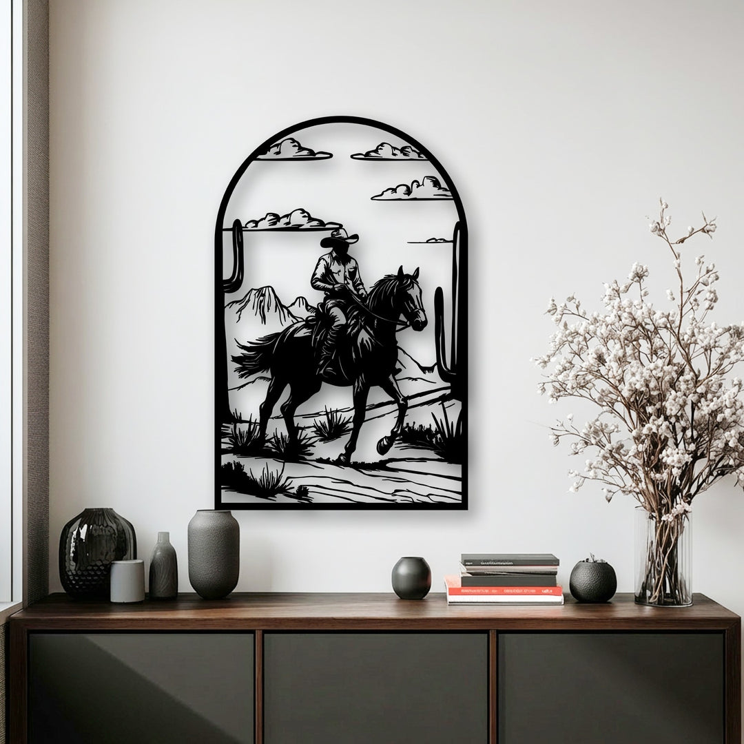 The focal point is a striking black silhouetted cowboy on horseback amidst a desert landscape, presented as captivating metal art for wall.