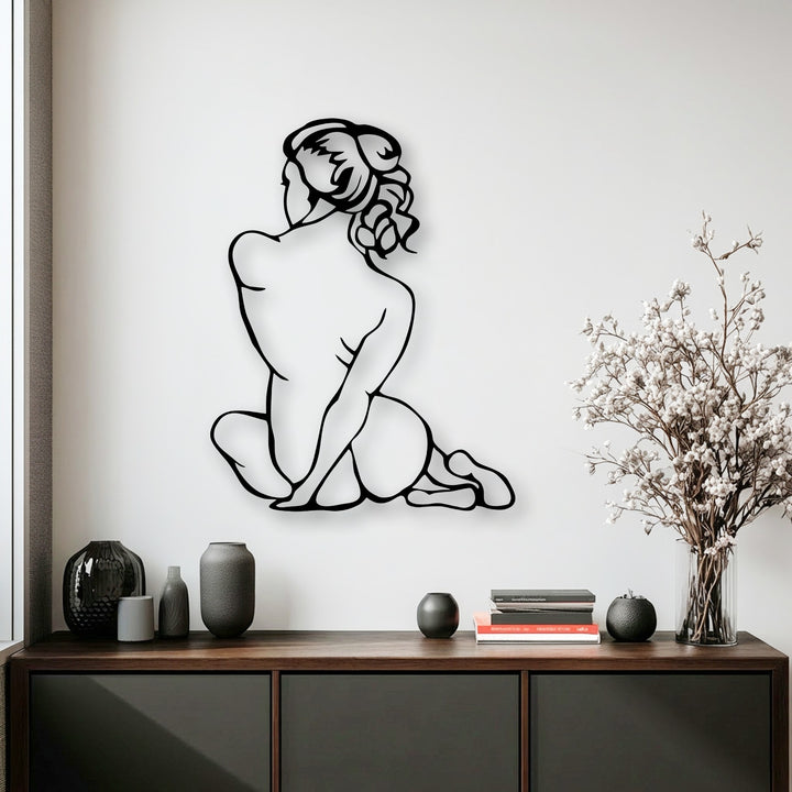 The elegant pose of the minimal female figure, captured in this unique metal wall art, conveys a fluid sense of turning movement.